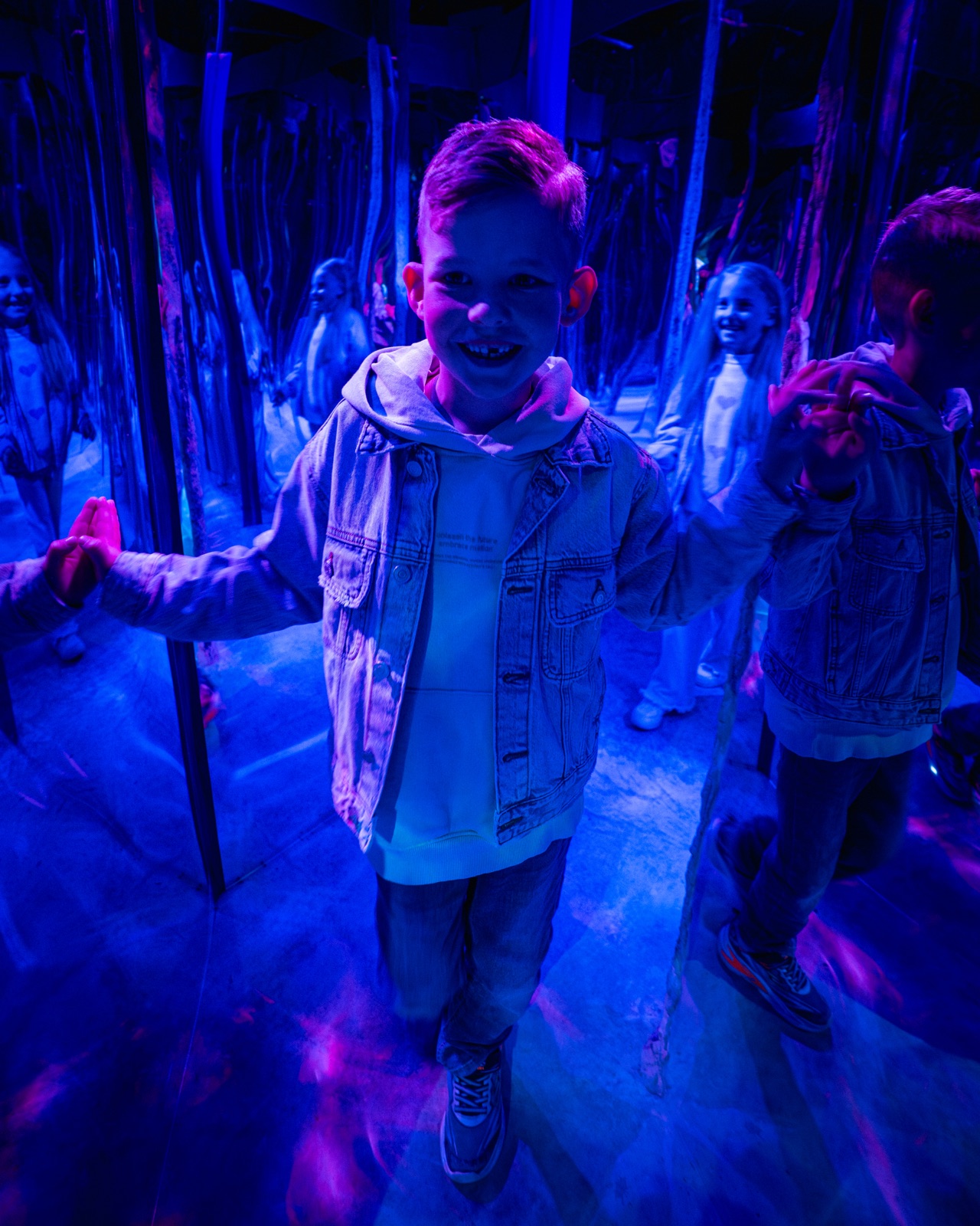 Junge im bunt beleuchteten Spiegellabyrinth im Taunus Wunderland